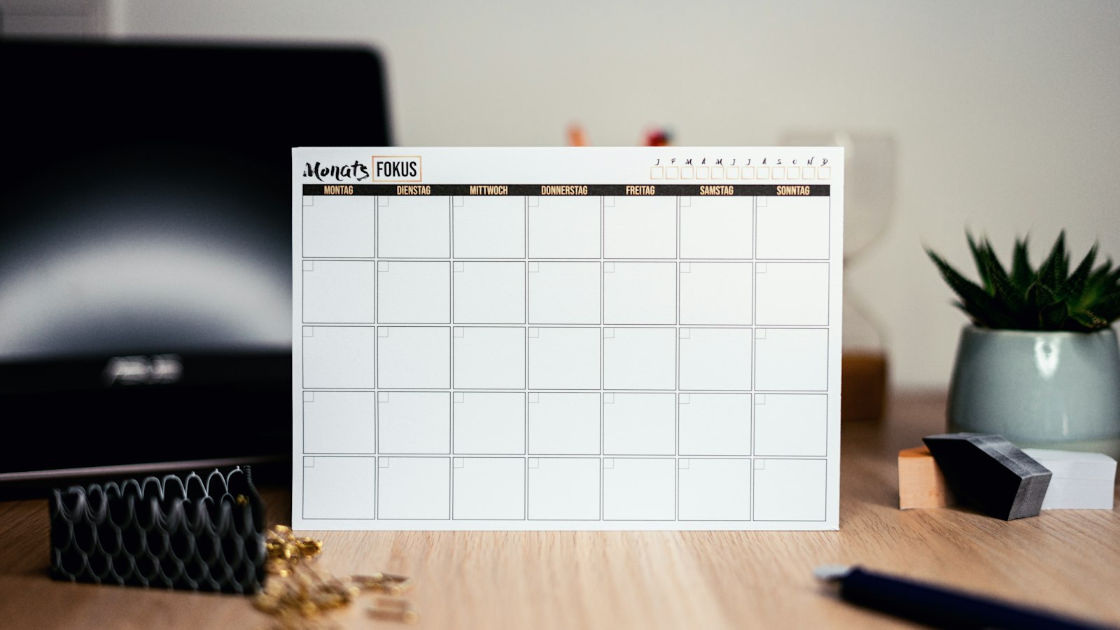A blank monthly planner standing on an office desk